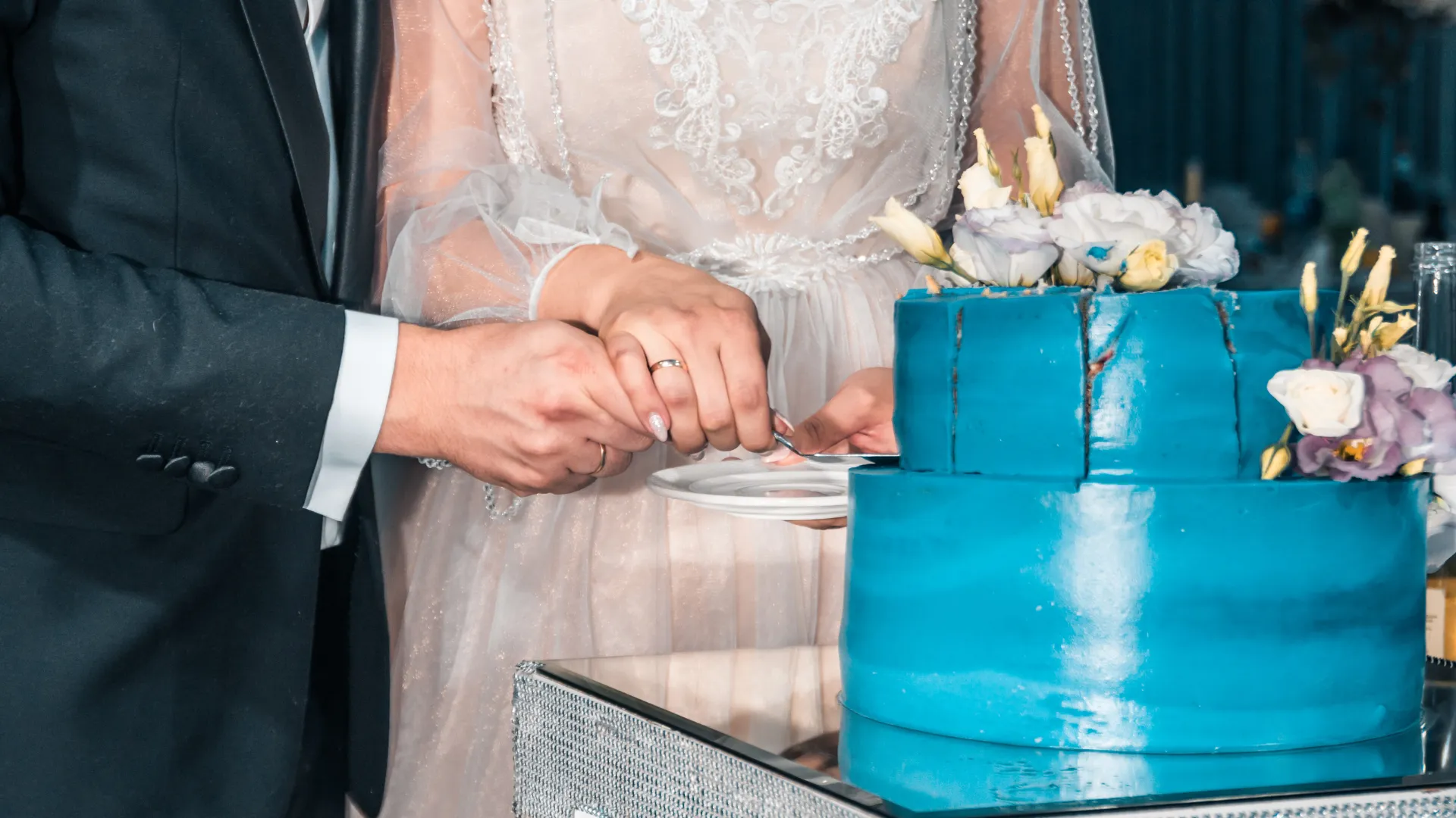 A couple cutting a wedding cake at a reception
